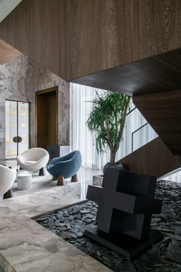 Modern marble and wood lobby with sculptural lounge chairs